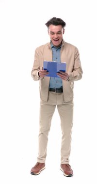 Zeki genç adamın harika bir fikri var. Havada yumrukla kutlama yapıyor ve beyaz arka planda yürüyüp gitmeden önce kafasını kaldırıyor.