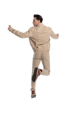 Dinamik bir gencin elleri havada atlayıp beyaz arkaplanın önünde yan yana durmasının arka planı.