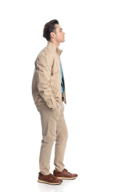 Ceplerinde el ele tutuşan ve beyaz arkaplanın önünde duran sıradan bir gencin yan görünüşü.