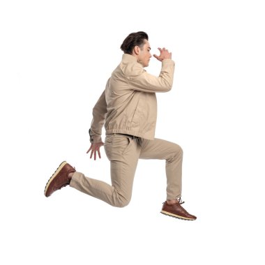 Beyaz arka planda kollarını kaldırıp havaya zıplayan dinamik sıradan adamın yan görünüşü