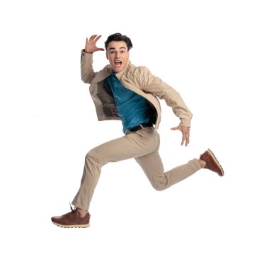 Sıradan dinamik bir adam, elleri havada beyaz arka planın önünde zıplıyor ve bağırıyor.