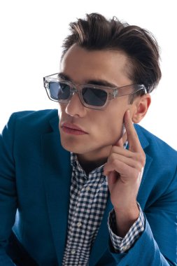 Modern güneş gözlüklü seksi genç adamın portresi beyaz arkaplan önünde yan yana duran ve yüzlerine dokunan