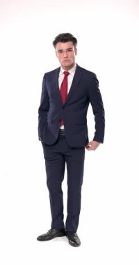 Kendine güvenen zarif iş adamı elleri ceplerinde yürüyor, hareket ediyor ve poz veriyor, avuçlarını ovuyor ve arkasına bakıyor, çenesine dokunuyor ve düşünceli davranıyor.