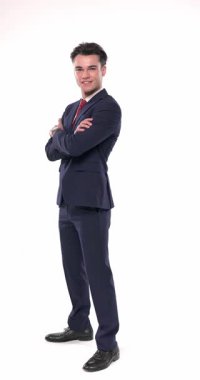 Zarif moda işadamı mutlu ve gülümsüyor, lacivert takımının düğmelerini açıyor ve cepleri dolu havalı bir şekilde poz veriyor.