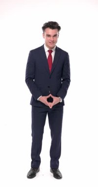 Kendine güvenen, gülümseyen, el ele tutuşan, hareket eden, kollarını kavuşturan ve beyaz arka planda duran bir adamın dikey videosu.