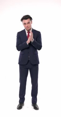 Mavi takım elbiseli, kırmızı kravat takan gururlu işadamı beyaz arka planda dikilirken parmağını öne uzatıp alkışlıyor.