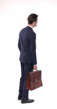 Lacivert takım elbiseli genç işadamı acele ediyor, beyaz arka planda kuyrukta beklerken saati kontrol ediyor.