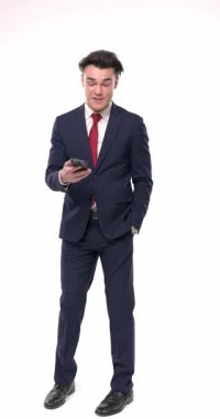 Mutlu, zarif iş adamının el ele yürüdüğü, telefona cevap verdiği ve beyaz arka planda dikilirken sohbet ettiği dikey bir video.