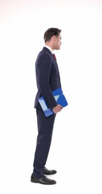 Lacivert takımlı zarif bir gencin elinde pano olan dikey videosu, saati kontrol ediyor ve beyaz arkaplan önünde kuyrukta bekliyor.