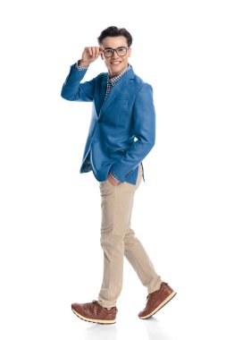 Gözlüklü mutlu genç adam el ele yürüyor ve beyaz arka planda gülümserken gözlük takıyor.