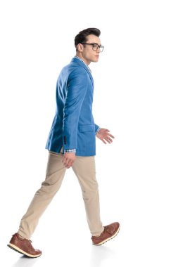 Gözlüklü genç adamın beyaz arka planda yürüdüğünü ve yan tarafa baktığını görüyorum.