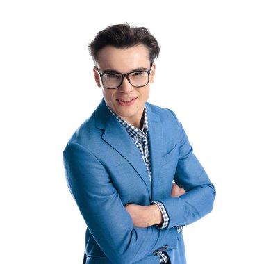 Gözlüklü, kollarını kaldıran ve beyaz arka planda gülümseyen kendinden emin bir gencin portresi.