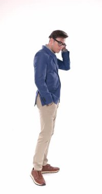 Mavi ceketli, aynaya bakıp, saçını düzelten, arkasını kameraya dönük ve ceplerinde el ele tutuşan seksi bir adamın yan görüntüsü.