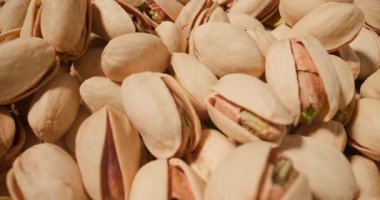 Antep fıstıklarının doğal kabukları ve parlak, lezzetli çekirdekleri ile yakın plan çekimleri.