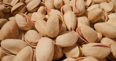 Antep fıstığının makro görüntüsü, gevrek, hafif desenli kabukları ve canlı yeşil fındıkları ortaya çıkarıyor.