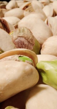 Antep fıstıklarının yakın çekimi, dokulu kabukların altını çizmek ve cevizlerin zengin, toprak yeşili tonları.