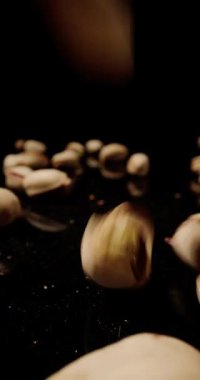 Siyah masaya düşen bir paket yeşil şam fıstığı siyah arka planda büyük bir kontrastlık yaratıyor.
