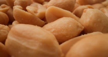 Yakından çekilen ve altın rengini ve pürüzsüz dokusunu vurgulayan çıtır çıtır fıstık yığını.