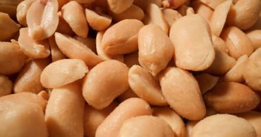 Bir grup tuzlu fıstığın küçük detaylarla yakalanması ve altın kabuklarını göstermeleri ve sağlıklı yağ ve protein kaynakları olmaları.