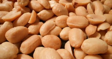 Tuzlu fıstık üzerine makro perspektif, pürüzsüz ve hafif tuzlu yüzeyi vurguluyor