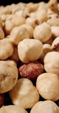 Kavrulmuş fındık, pürüzsüz altın yüzeyler ve kırsal kahverengi deri parçalarının karışımını sergiliyor.