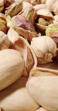 Antep fıstıklarının yakın çekimi, dokulu kabukların altını çizmek ve cevizlerin zengin, toprak yeşili tonları.