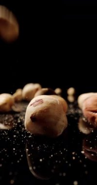 Düşen fındıklar, yüzeye çıktıklarında beklenmedik bir şekilde zıplayan ritmik bir dans yaratır.