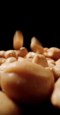 Yerfıstığı yağmuru yukarıdan düşer, kabukları yumuşak ve dağınık bir darbeyle yüzeye vurur.