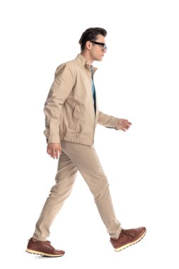 Gözlüklü yakışıklı sıradan bir adam stüdyoda beyaz arka planda yürüyordu.