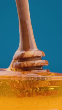 Altın bal damlıyor yumuşak bir girdap, kalın, yapışkan ve tatlı doğada hareket halindeki sıvı altın