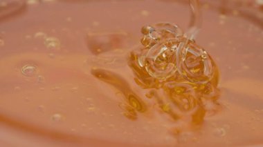 Altın bal damlıyor yumuşak bir girdap, kalın, yapışkan ve tatlı doğada hareket halindeki sıvı altın