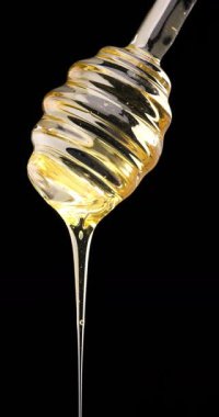 Saf bal çiselemesi bu saf, organik tatlandırıcının zengin dokusunu ve doğal altın parıltısını yakalıyor