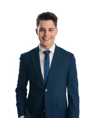 Mavi takım elbiseli gururlu bir iş adamı beyaz arka planda dururken gülümsüyor ve poz veriyor.