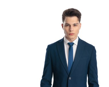 Lacivert takımlı seksi genç işadamının portresi ileriye bakıyor ve beyaz arkaplanın önünde duruyor.