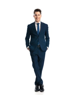 Lacivert takım elbiseli mutlu genç işadamı, beyaz arka planda dururken el ele tutuşup gülümsüyor.