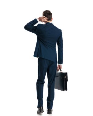 Lacivert takım elbiseli, kafası karışık genç iş adamlarının beyaz arka planda yürürken kafalarını kaşıyıp düşünmeleri.