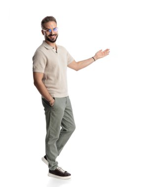 Gözlüklü yakışıklı bir adamın yan görünüşü yan yana ve gülümsüyor, el ele tutuşup beyaz arka planda yürüyor.