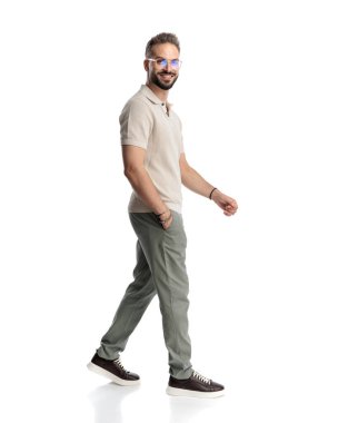 Gözlüklü, el ele yürüyen ve beyaz arka planda gülümseyen yakışıklı sakallı adamın yan görüntüsü.