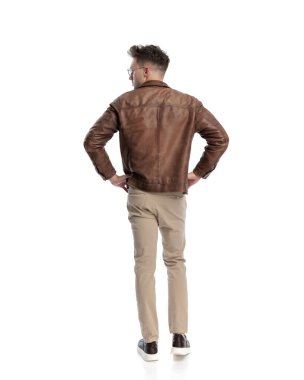 Gözlüklü, kalçasında el ele tutuşan, beyaz arka planın önünde duran sıradan bir gencin arka plan görüntüsü.