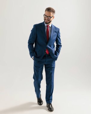 Gözlüklü mutlu, zarif bir iş adamı. Gri arka planda el ele yürüyor.