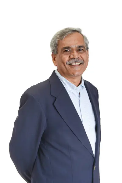 白で隔離された明るいブルーのシャツと緑の袖口で灰色の髪を持つ笑顔のインドのビジネスマンまたは幹部 ロイヤリティフリーのストック写真