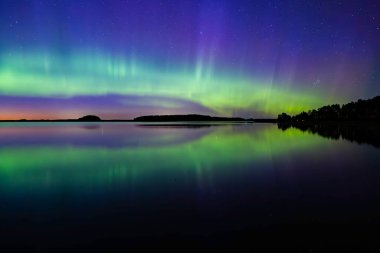 İsveç 'teki sakin göl üzerindeki kuzey ışıklarının manzarası (Aurora borealis) Farnebofjarden Milli Parkı