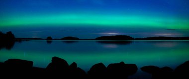 İsveç 'teki sakin göl üzerindeki kuzey ışıklarının manzarası (Aurora borealis) Farnebofjarden Milli Parkı