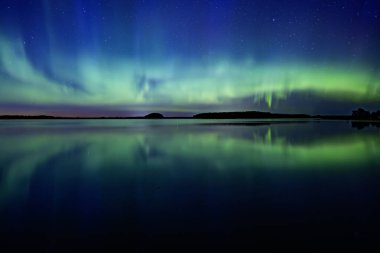 İsveç 'teki sakin göl üzerindeki kuzey ışıklarının manzarası (Aurora borealis) Farnebofjarden Milli Parkı