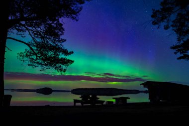 İsveç 'teki sakin göl üzerindeki kuzey ışıklarının manzarası (Aurora borealis) Farnebofjarden Milli Parkı