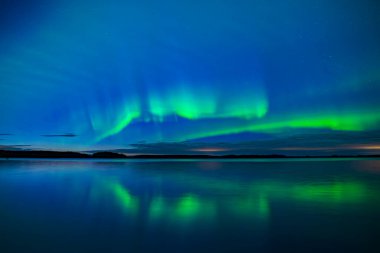 İsveç 'teki sakin göl üzerindeki kuzey ışıklarının manzarası (Aurora borealis) Farnebofjarden Milli Parkı