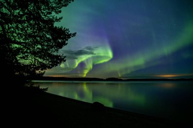 İsveç 'teki sakin göl üzerindeki kuzey ışıklarının manzarası (Aurora borealis) Farnebofjarden Milli Parkı