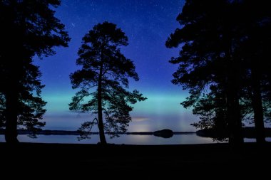 İsveç 'teki sakin göl üzerindeki kuzey ışıklarının manzarası (Aurora borealis) Farnebofjarden Milli Parkı