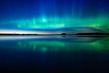 İsveç 'teki sakin göl üzerindeki kuzey ışıklarının manzarası (Aurora borealis) Farnebofjarden Milli Parkı