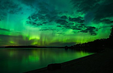 İsveç 'teki sakin göl üzerindeki kuzey ışıklarının manzarası (Aurora borealis) Farnebofjarden Milli Parkı